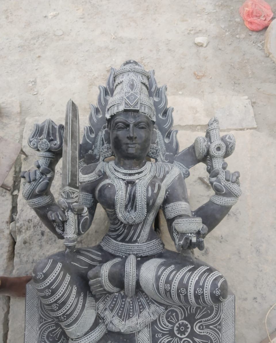 Carved granite Durga figure with eight arms holding weapons