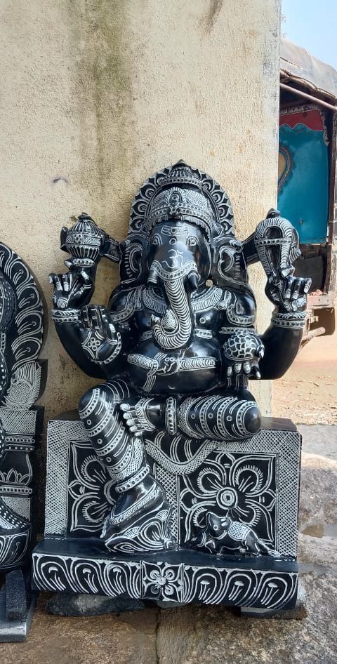 Black granite Ganesha carved in relief above a decorated base