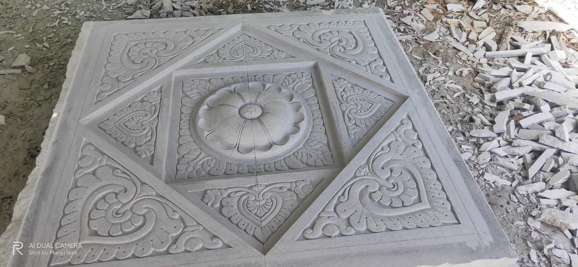 Square granite ceiling panel with a central rosette and scrolled border