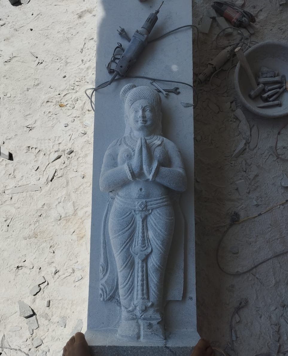 Granite panel with a standing female guardian figure carved in relief