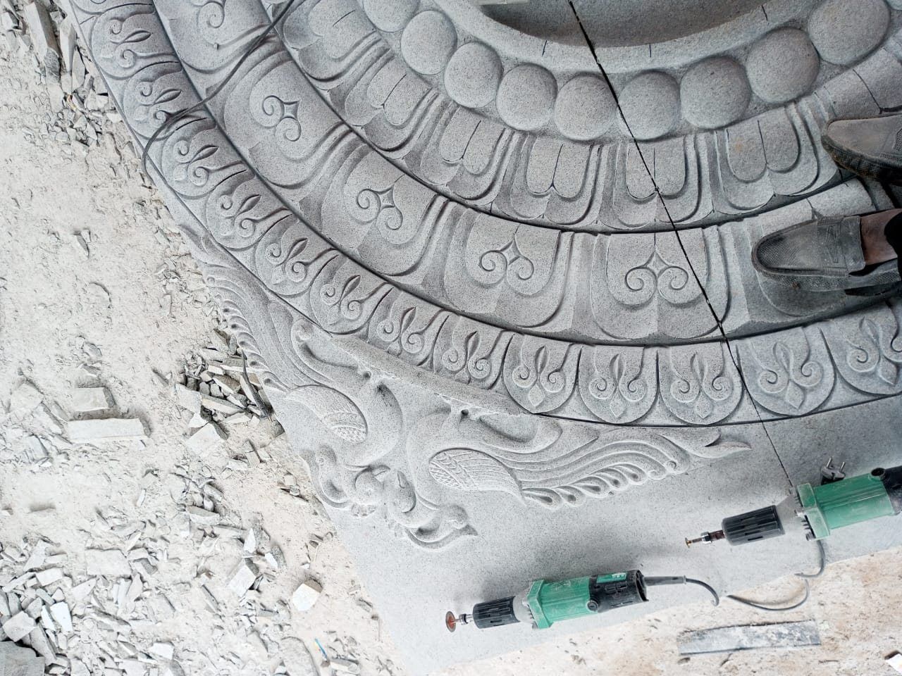 Lotus ceiling medallion part-carved with chisels lying on the stone