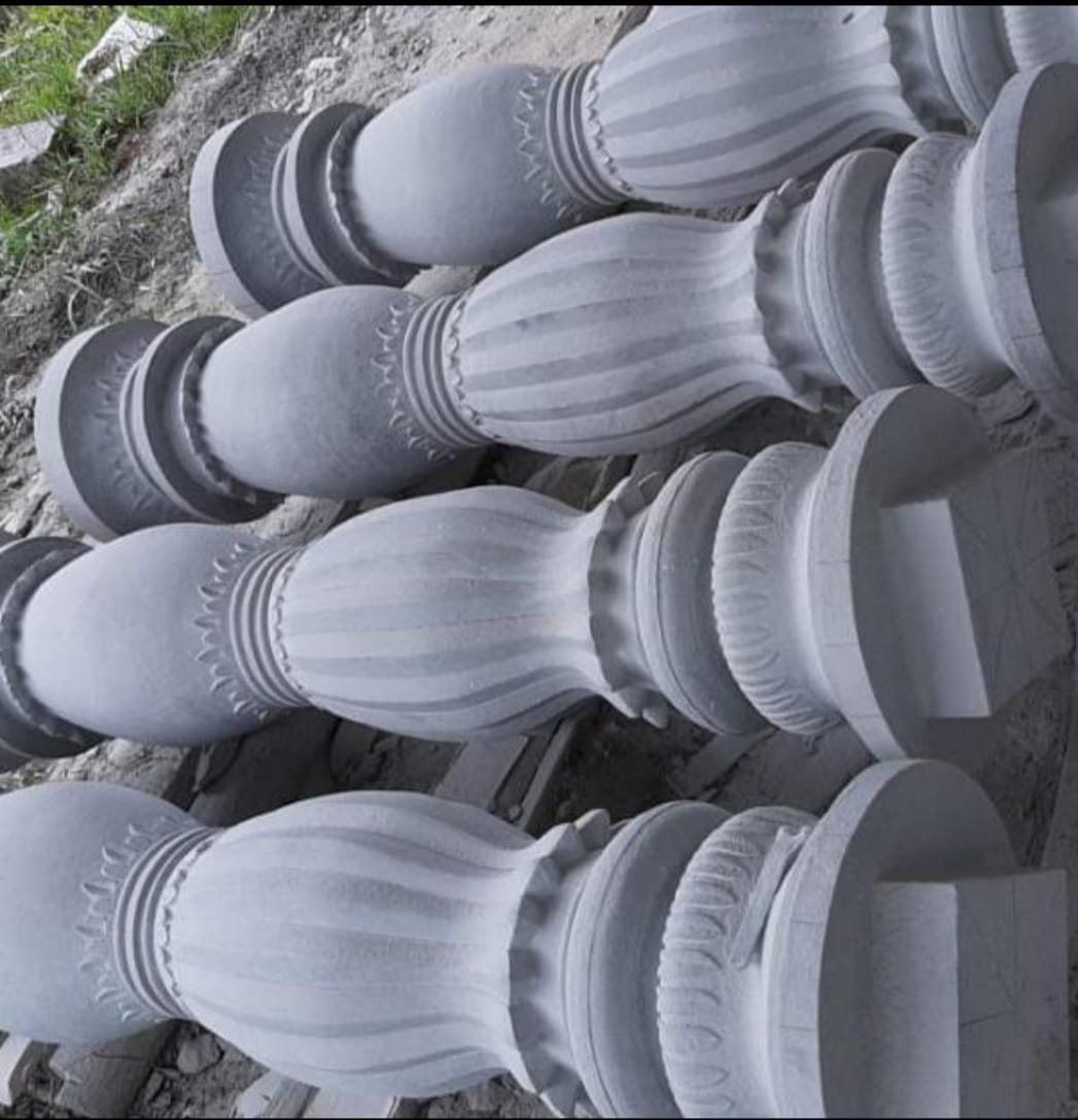 Rows of fluted granite pillar bases stacked in the yard