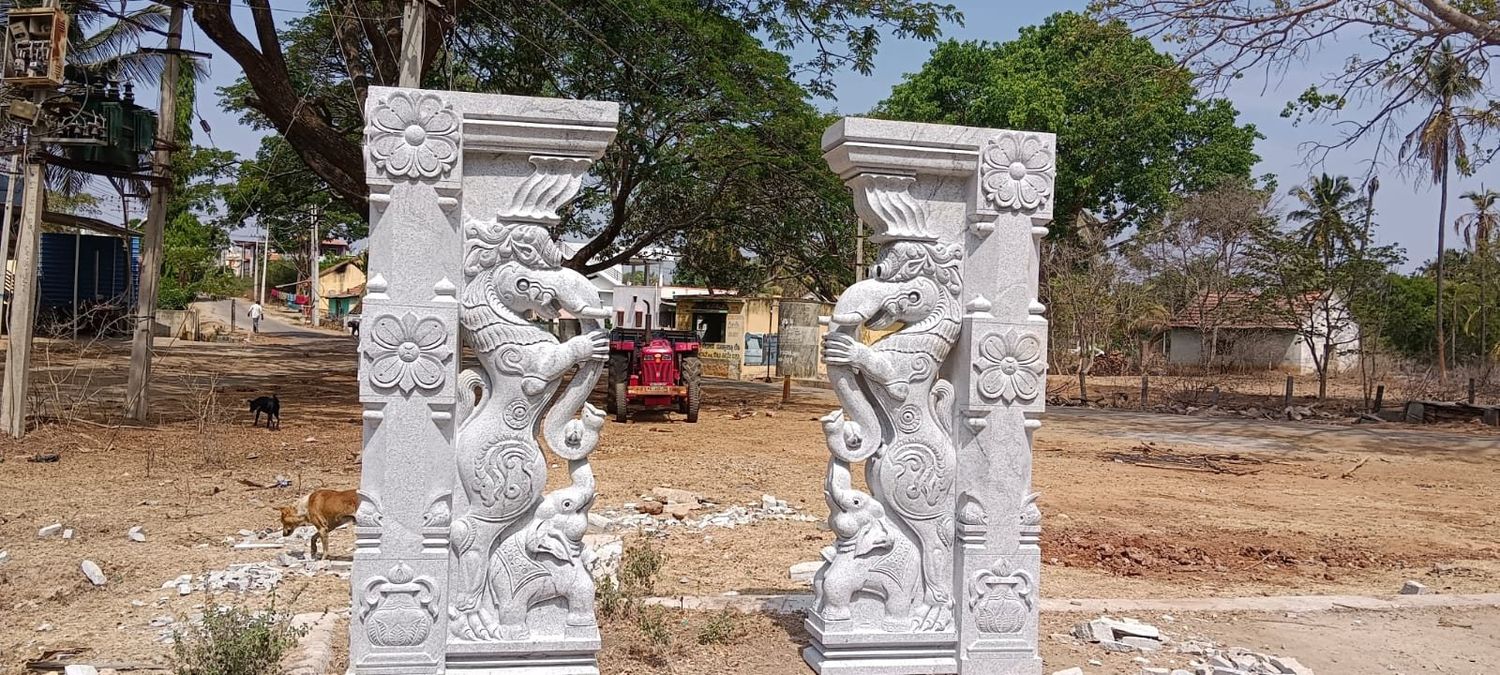 A matched pair of carved yali pillars standing on site