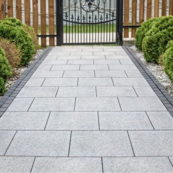 Large-format stone slabs laid as a drive apron